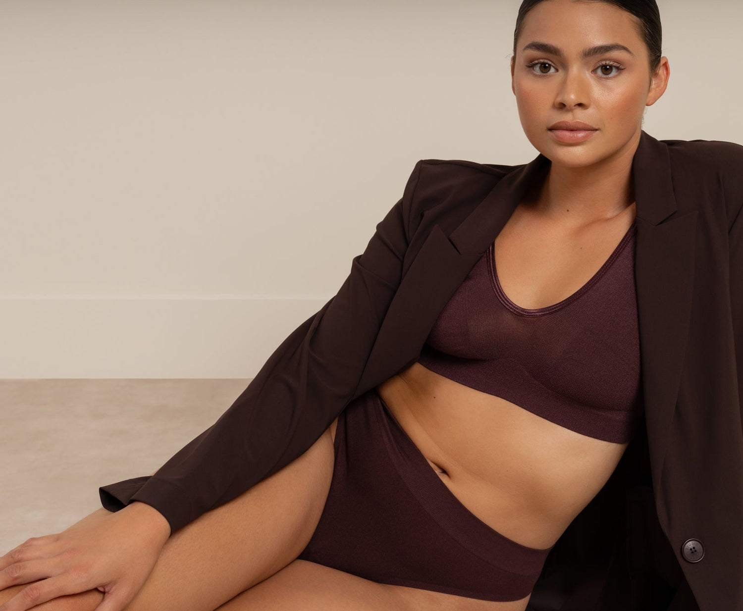 Model draagt een donkerbruine Studio Anneloes blazer en een bijpassende Soft Revolt bralette met slip