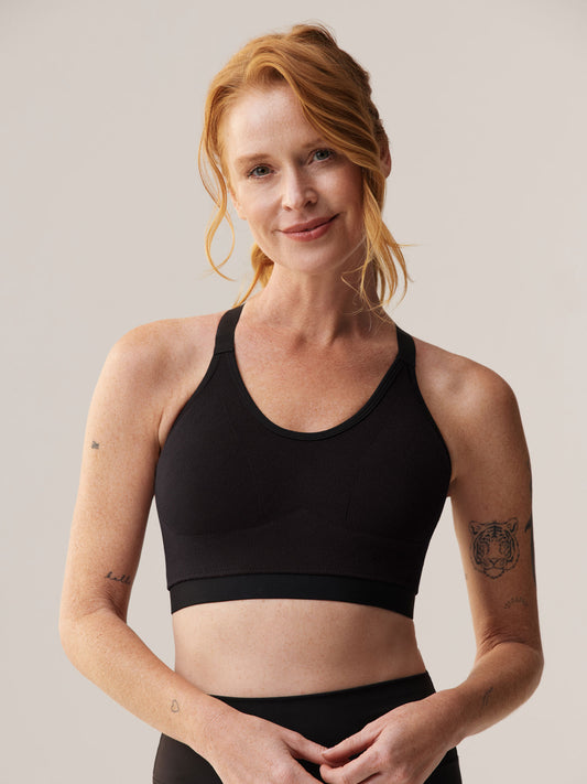 Vooraanzicht van Elize Been in de beugelloze zwarte Soft Revolt sport-bh: maximale ondersteuning en draagcomfort voor dames met een grotere cupmaat
