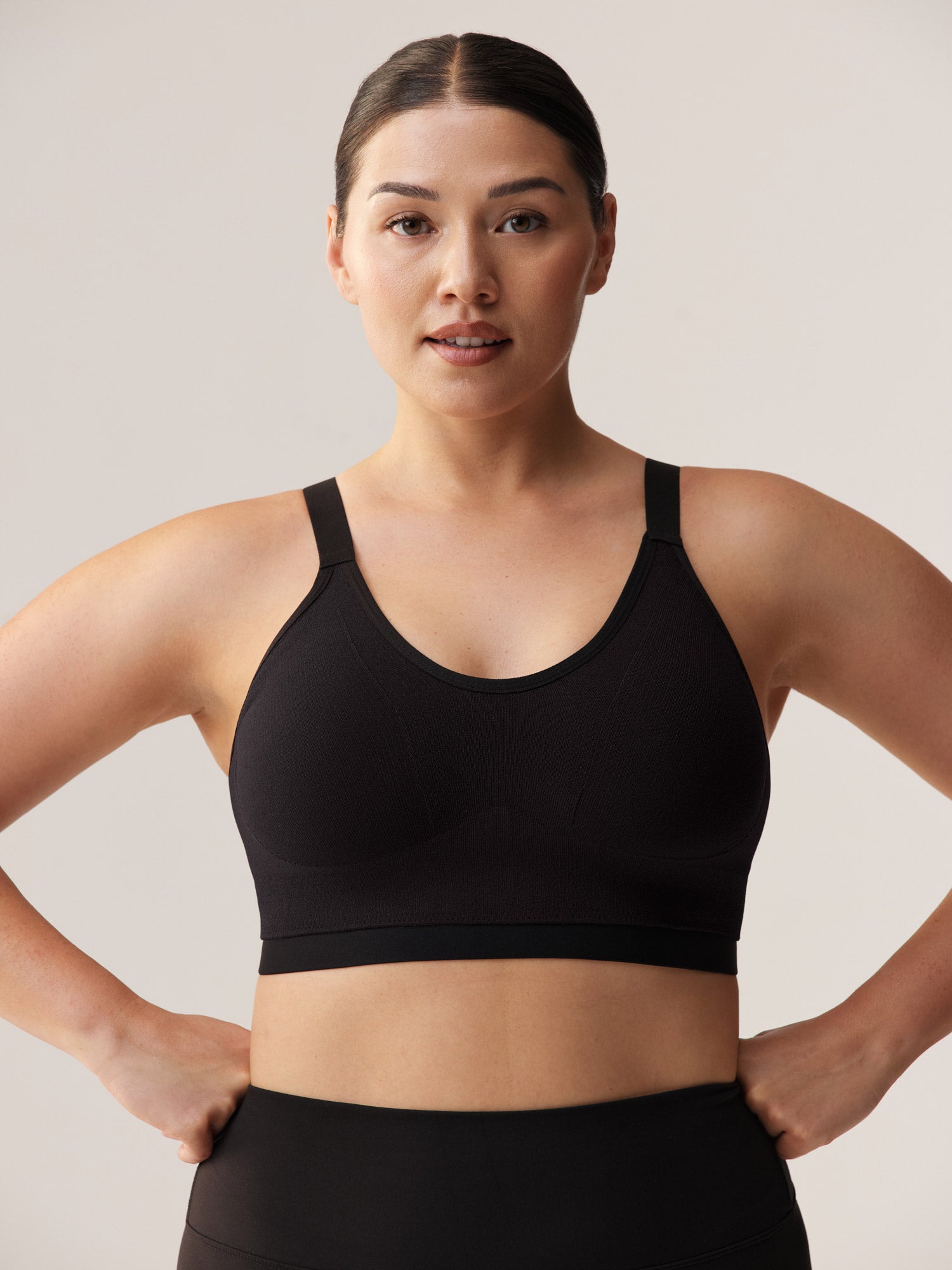 Vooraanzicht van een krachtige, ondersteunende zwarte sport-bh voor vollere cupmaten, met brede zachte schouderbanden en een stevige onderband voor maximaal comfort.