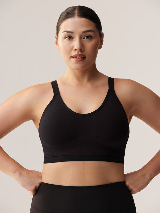 Vooraanzicht van een krachtige, ondersteunende zwarte sport-bh voor vollere cupmaten, met brede zachte schouderbanden en een stevige onderband voor maximaal comfort.