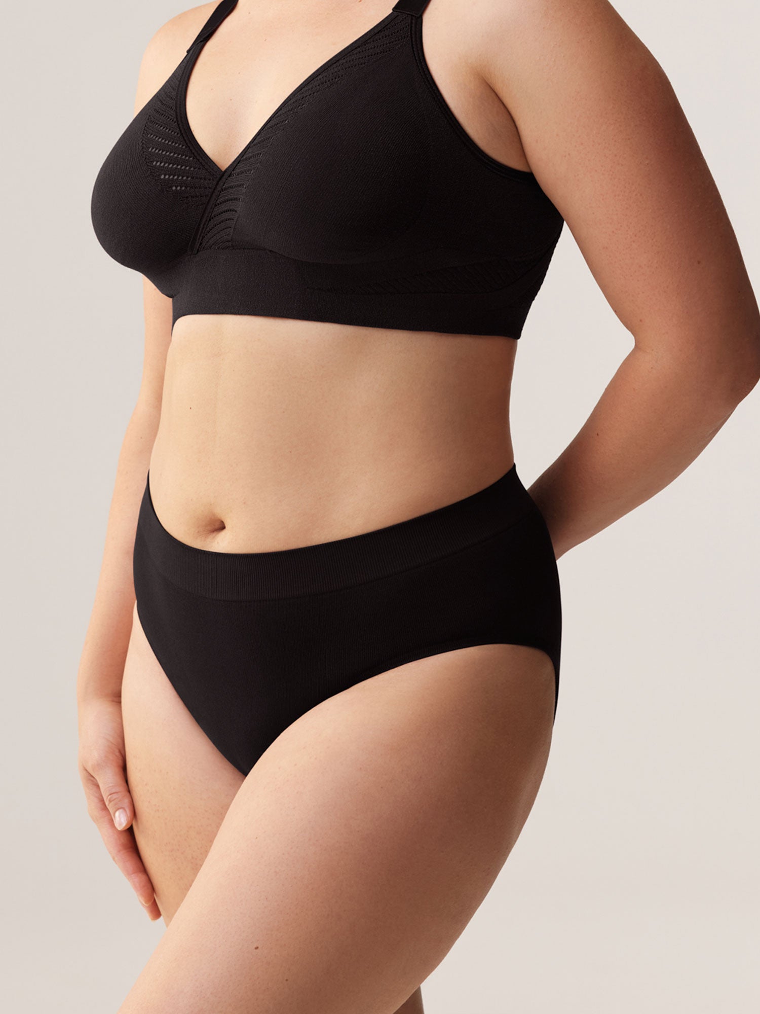 Zijaanzicht van model in de zwarte Soft Revolt Classic Slip Black high-waist en naadloos