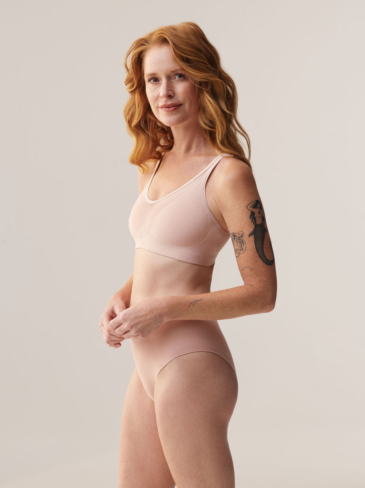 Driekwart vooraanzicht van de Soft Revolt Lara BH soft pink gedragen door model Elize Been, duurzaamheid influencer, voor een grote cupmaat