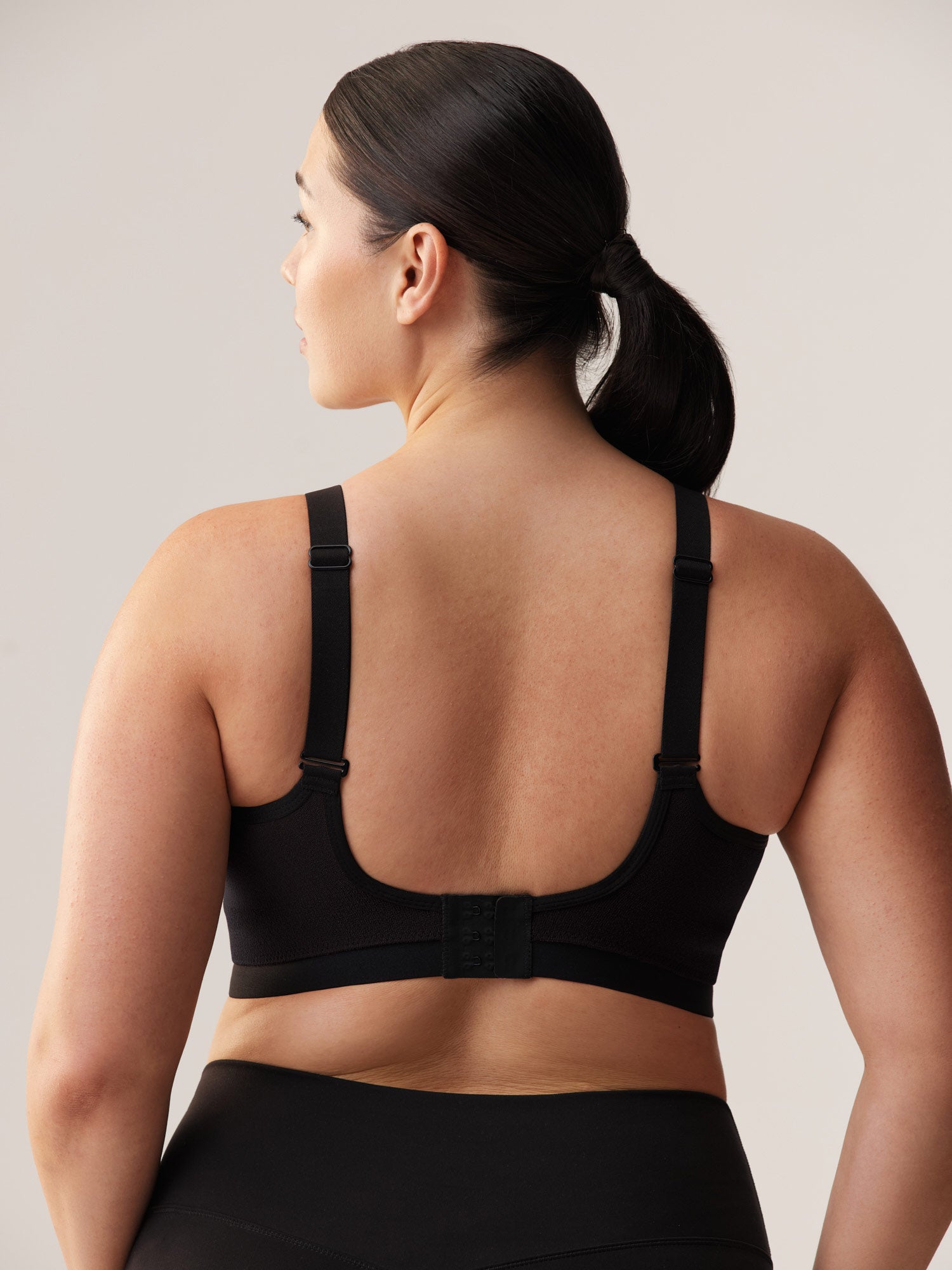 Achterzijde van de zwarte Soft Revolt Milou Active Bra: naadloze sport-bh met haaksluiting op de rug en rechte, verstelbare schouderbanden voor vollere cupmaten