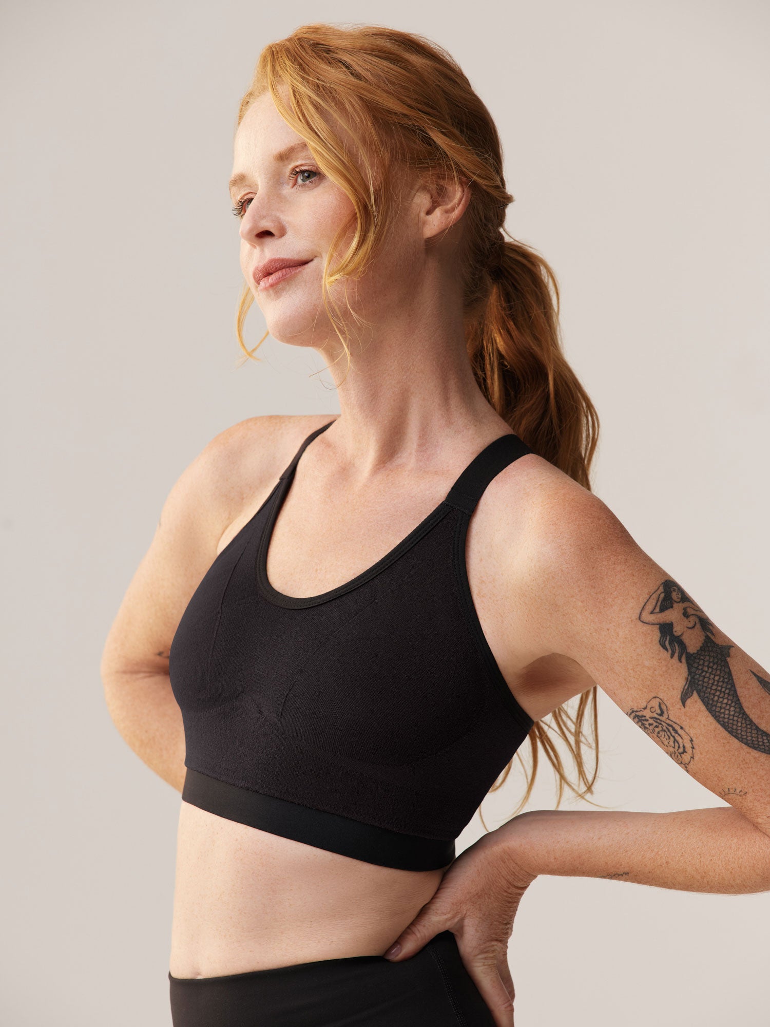 Elize Been in profiel met de zwarte Soft Revolt sport-bh voor vollere cupmaten: beugelloos design voor optimale zij-steun en comfort tijdens het sporten.